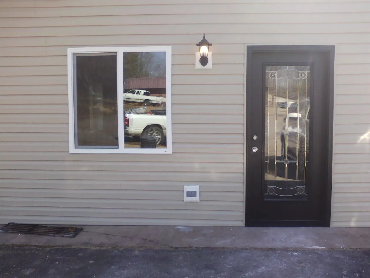 New siding, window and entry door on the side of an addition in Pomona